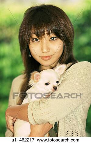 Young woman holding a puppy View Large Photo Image Stock Photo - Young woman holding a puppy . Fotosearch