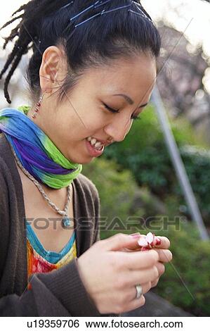 Young woman holding cherry blossoms View Large Photo Image Stock Photograph - Young woman holding cherry blossoms. Fotosearch
