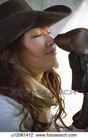 Stock Image - Young woman indoors with dog, stuffed toy. Fotosearch