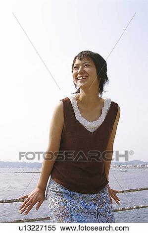 Stock Photography - Young woman leaning against rope. Fotosearch