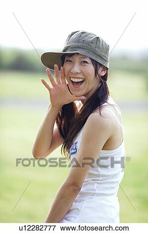 Young woman looking back in field of grass View Large Photo Image Stock Photo - Young woman looking back in field of grass . Fotosearch