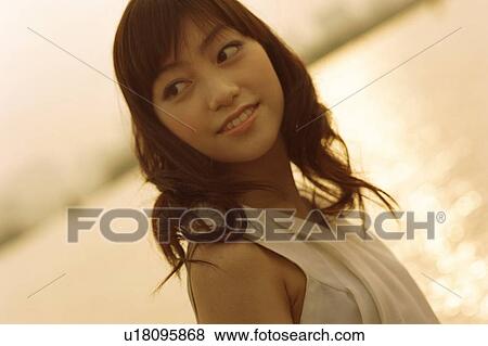 Stock Photo - Young woman looking back, portrait. Fotosearch