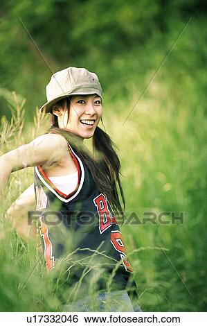 Stock Photograph - Young woman looking back, portrait. Fotosearch
