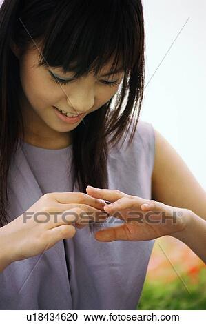 Young woman looking her hands View Large Photo Image Stock Image - Young woman looking her hands. Fotosearch