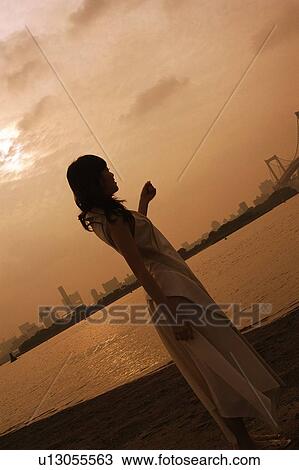 Stock Image - Young woman looking out over the river. Fotosearch