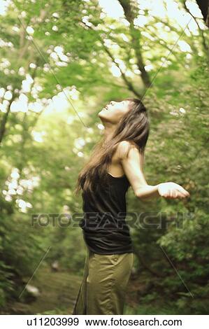 Young woman looking up with open arms View Large Photo Image Stock Photo - Young woman looking up with open arms . Fotosearch