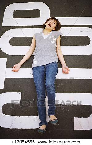 Stock Photography - Young woman lying on the street, portrait . Fotosearch