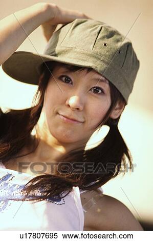 Stock Photography - Young woman smiling with her hand on her head. Fotosearch