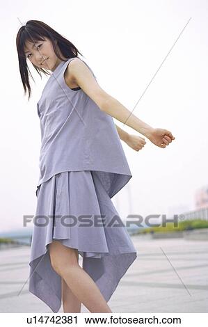 Stock Image - Young woman standing, portrait. Fotosearch