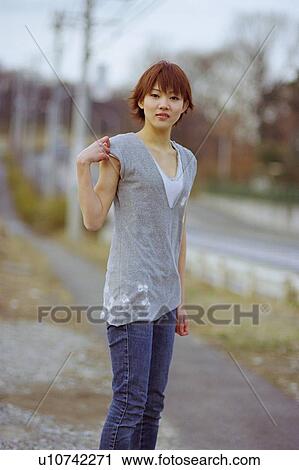 Stock Image - Young woman standing. Fotosearch