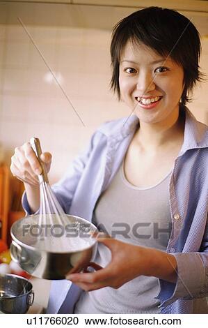 Young woman stirring mixture in a bowl, portrait View Large Photo Image Stock Image - Young woman stirring mixture in a bowl, portrait. Fotosearch