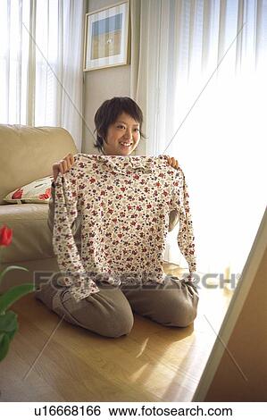 Stock Photograph - Young woman trying on clothes . Fotosearch