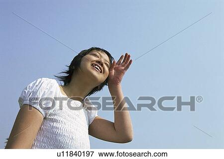 Stock Photo - Young woman wiping sweat from her forehead . Fotosearch