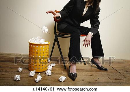Stock Image - Business Woman and the Rubbish Bin. Fotosearch