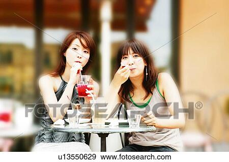 Stock Photo - Two Young Adult Women at the caf?. Fotosearch
