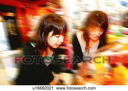 Stock Image - Two Young Adult Women Playing Games. Fotosearch