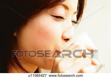 Stock Photo - Young Adult Woman Dinking a water. Fotosearch
