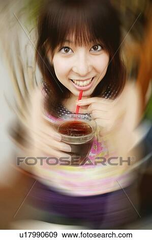 Stock Photo - Young Adult Woman Drinking a Juice. Fotosearch