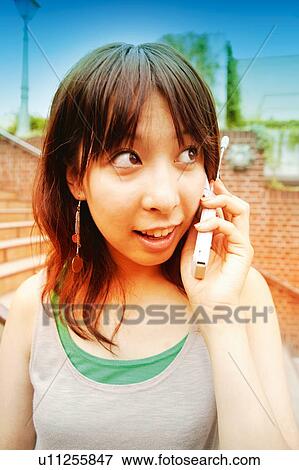 Stock Photo - Young Adult Woman talking on the phone. Fotosearch