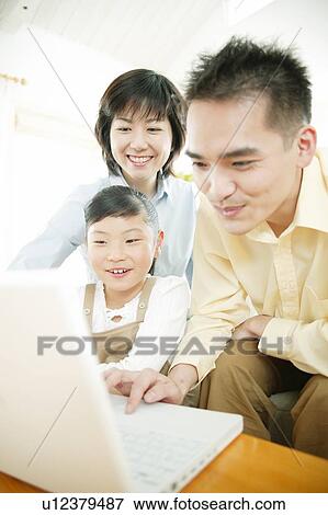 Family playing a PC View Large Photo Image Stock Photo - Family playing a PC. Fotosearch