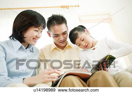 Family reading a book View Large Photo Image Stock Photo - Family reading a book. Fotosearch