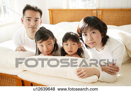 Stock Photo - Family sprawling in the bed. Fotosearch