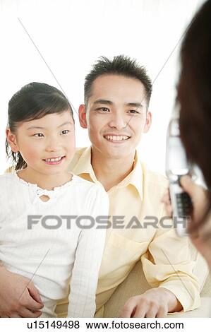 Stock Photo - Family taking a photo by the portable telephone. Fotosearch
