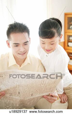 Father and child reading a newspaper View Large Photo Image Stock Photo - Father and child reading a newspaper. Fotosearch