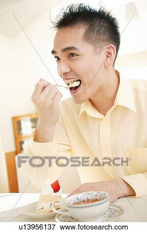 Man eating a cake View Large Photo Image Stock Photo - Man eating a cake. Fotosearch