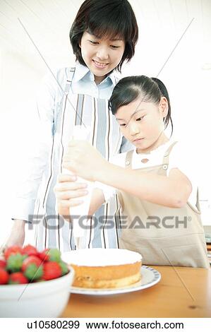 Stock Photo - Mother and child making a cake. Fotosearch