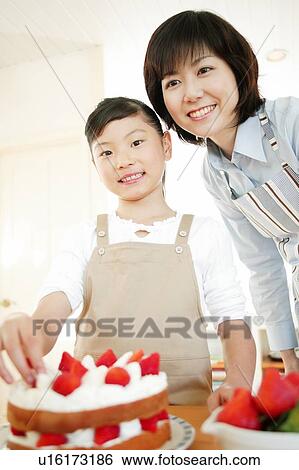 Stock Photograph - Mother and child making a cake. Fotosearch