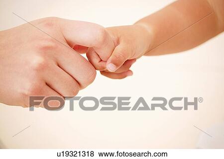A Baby Girl holding her mother's finger View Large Photo Image Stock Photo - A Baby Girl holding her mother's finger. Fotosearch