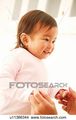 Picture - A Baby Girl Holding her mother's hand. Fotosearch
