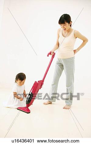 A Baby Girl interrupting of her mothers cleaning View Large Photo Image Stock Image - A Baby Girl interrupting of her mothers cleaning. Fotosearch