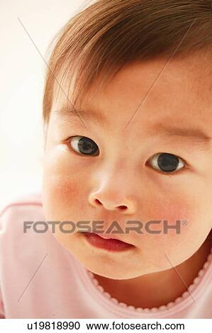 Stock Image - A Baby Girl looking at camera. Fotosearch