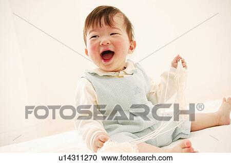 Stock Image - A Baby Girl playing with woolen thread. Fotosearch