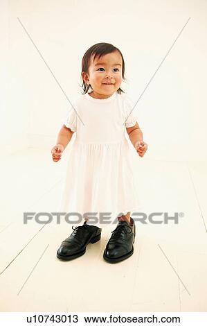 A Baby Girl wearing her father's shoes View Large Photo Image Stock Image - A Baby Girl wearing her father's shoes. Fotosearch