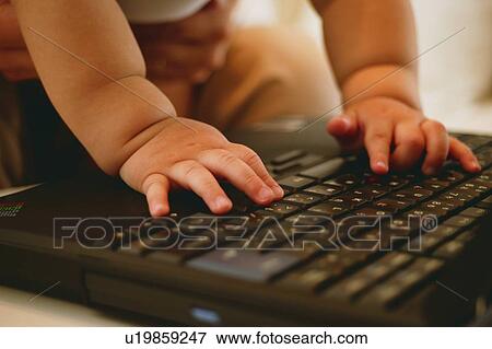 A Baby playing with a computer View Large Photo Image Stock Photo - A Baby playing with a computer. Fotosearch