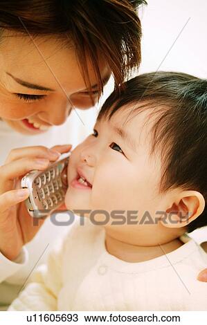 Stock Image - A Baby Playing with a mobile phone. Fotosearch