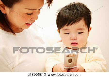 Stock Image - A Baby Playing with a mobile phone. Fotosearch