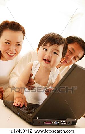 Family playing with a computer View Large Photo Image Stock Image - Family playing with a computer. Fotosearch