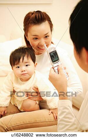 Stock Image - Family taking a photograhy by mobile phone. Fotosearch
