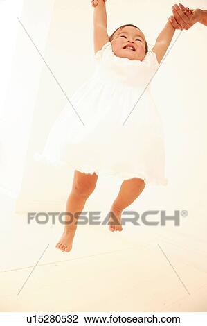 Stock Image - Father holding up his daughter. Fotosearch