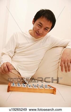 Stock Photo - Father playing a toy glockenspiel. Fotosearch