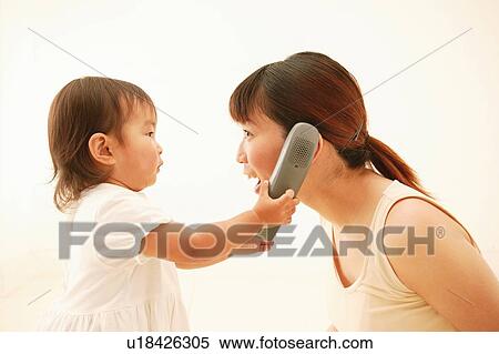 Mother and her daughter playing with a phone View Large Photo Image Stock Photography - Mother and her daughter playing with a phone. Fotosearch