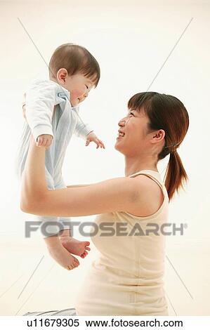 Stock Photography - Mother lifting up her son. Fotosearch
