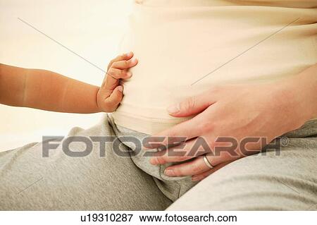 Stock Photo - Pregnant Woman and baby's hand. Fotosearch