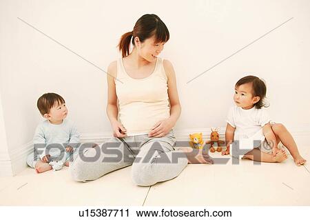 Stock Image - Pregnant Woman and her daughters. Fotosearch