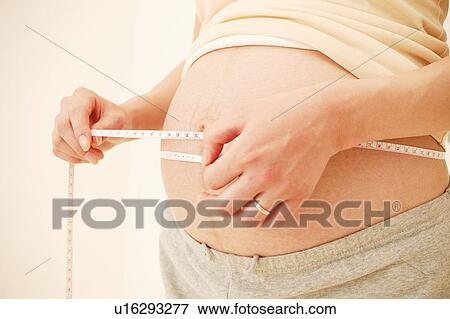 Pregnant Woman Measuring her waist View Large Photo Image Stock Photo - Pregnant Woman Measuring her waist. Fotosearch