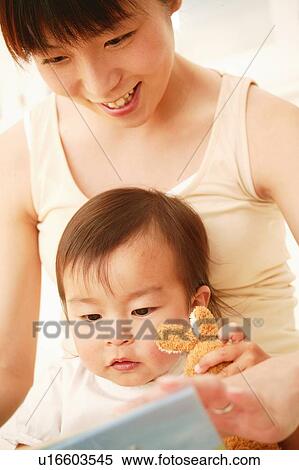 Stock Photography - Pregnant Woman reading a children's book for her daughter. Fotosearch